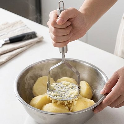 Presse purée bol en inox sur un comptoir blanc