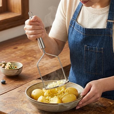 Presse purée dame en tablier en jeans
